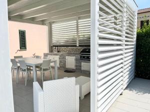 a patio with a table and chairs and a kitchen at Casa Roccella in Buonfornello