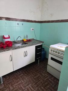 a kitchen with a sink and a stove at Casa confortável e central in Poços de Caldas