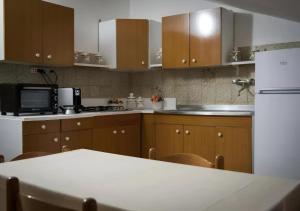 a kitchen with wooden cabinets and a white refrigerator at B&B SANTA MARIA VALLEVERDE appartamento vicinissimo alla Clinica L'immacolata in Celano +4 photos