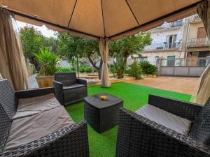 an outdoor patio with chairs and an umbrella at Casa Mandarino con Parcheggio in Conversano