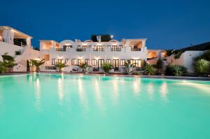 a large swimming pool in front of a house at Anastasis Apartments and Spa in Imerovigli
