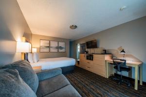 a hotel room with a bed and a couch at Courtesy Inn Downtown Eugene in Eugene