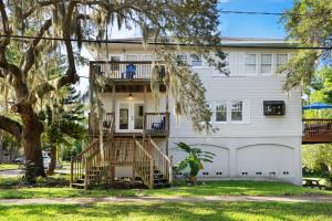 a white house with a tree and stairs at Cruise the waterways from your backyard in Bradenton