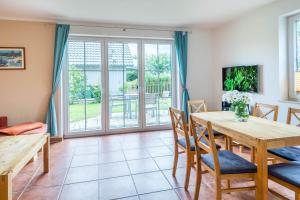 a living room with a wooden table and chairs at Ferienwohnung Katharina EG in Wohlenberg