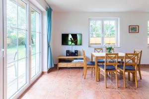 a dining room with a table and chairs and windows at Ferienwohnung Katharina EG in Wohlenberg