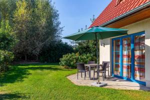 a patio with a table and chairs and an umbrella at Ferienwohnung Katharina EG in Wohlenberg