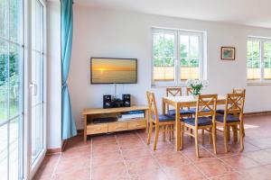 a dining room with a table and chairs and a tv at Ferienwohnung Katharina EG in Wohlenberg
