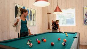 two women playing pool in a room with a pool table at Villavilla 171 - Ebeltoft, Østjylland in Ebeltoft