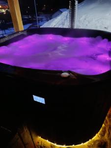 a hot tub filled with purple water in the snow at Czesławka in Zawoja +55 photos