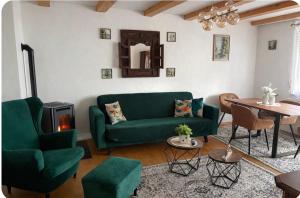 ein Wohnzimmer mit einer grünen Couch und einem Tisch in der Unterkunft MPK Motorsport Apartment in Waldsassen