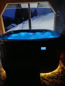 a hot tub in front of a window with snow at Czesławka in Zawoja