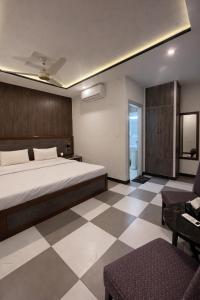 a bedroom with a bed and a checkered floor at Hotel Noor Sky in Islamabad