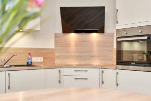a kitchen with white cabinets and a sink at Deichläufer in Ockholm