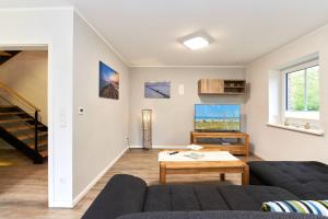 a living room with a couch and a tv at Deichläufer in Ockholm +10 photos
