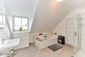 a bathroom with a bath tub and a sink at Deichläufer in Ockholm