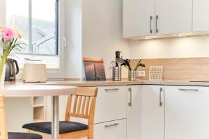 a kitchen with white cabinets and a table and chairs at Deichläufer in Ockholm
