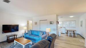 a living room with a blue couch and a table at Atlantic Breeze #7 in Jekyll Island