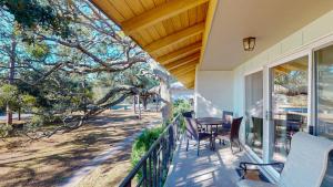 a porch with chairs and a table and a tree at Atlantic Breeze #7 in Jekyll Island