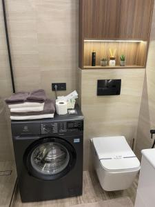 a bathroom with a washing machine and a toilet at Апартаменти Оливкова симфонія in Zhytomyr +31 photos
