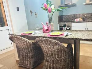 a kitchen with a counter with two chairs and a table at Palm Oasis Bonaire in Kralendijk