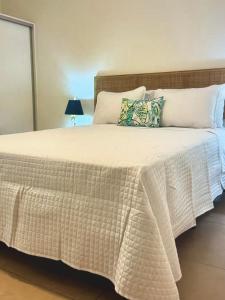 a bed with a white blanket and pillows at Palm Oasis Bonaire in Kralendijk