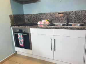 a kitchen with white cabinets and a sink at Palm Oasis Bonaire in Kralendijk +8 photos