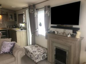 ein Wohnzimmer mit Kamin und Flachbildfernseher in der Unterkunft Annalake in Grange Over Sands