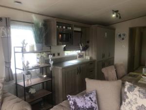 ein Wohnzimmer mit Sofa und eine Küche in der Unterkunft Annalake in Grange Over Sands