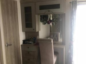 eine Küche mit einem Tisch, einem Stuhl und einem Schrank in der Unterkunft Annalake in Grange Over Sands + 19 Fotos