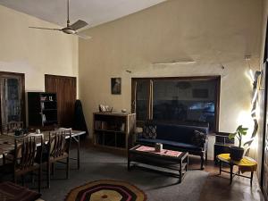 a living room with a couch and a table and chairs at Rooms In Central Rawalpindi in Rawalpindi
