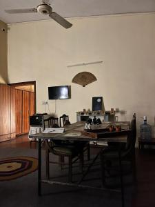 a living room with a table with chairs and a ceiling fan at Rooms In Central Rawalpindi in Rawalpindi +7 photos