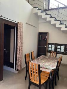 a dining room with a table and chairs and a staircase at The 9th Oasis in Hyderabad +1 photo