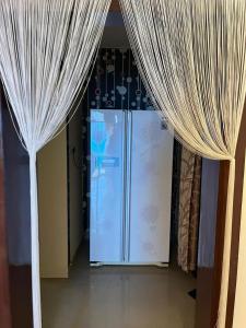 a refrigerator is in a room with curtains at The 9th Oasis in Hyderabad