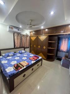 a bedroom with a bed with a blue comforter at The 9th Oasis in Hyderabad
