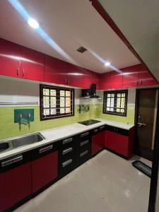 a kitchen with red cabinets and a sink at The 9th Oasis in Hyderabad