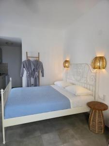 a bedroom with a white bed with a blue comforter at Sunset Paradise Oia in Oia +76 photos