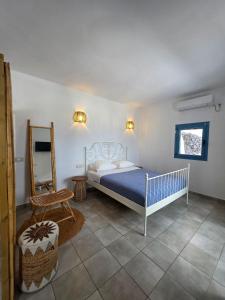 a bedroom with a bed and a chair and a mirror at Sunset Paradise Oia in Oia