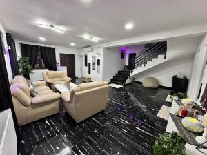 a living room with two couches and a staircase at Enjoy VIP House 10 in Măgurele