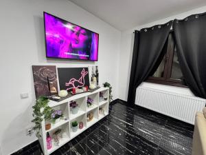 a living room with a tv on a wall at Enjoy VIP House 10 in Măgurele