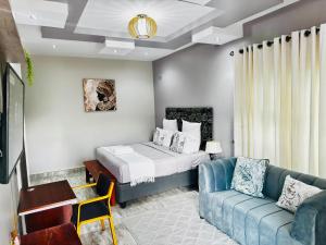 a living room with a bed and a couch at Falcon Guest House in Harare