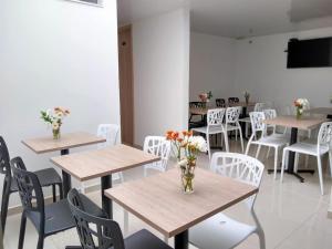 a room with tables and chairs with flowers on them at Hotel Federman Park Bogota in Bogotá