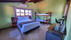 a bedroom with a bed and a chair and a desk at Recanto da Dona Luiza - Pousada in Florianópolis +48 photos