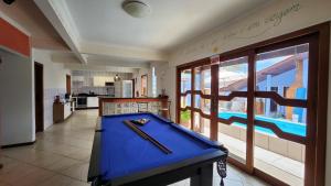 a pool table in a living room with a kitchen and a pool at Recanto da Dona Luiza - Pousada in Florianópolis