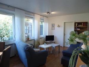 a living room with two blue couches and a tv at Haus am Burgberg in Frankenberg