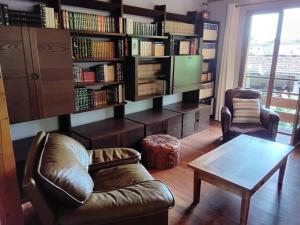 a living room with a couch and a table and bookshelves at Le Rucan Maison atypique in Montastruc-de-Salies