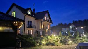 a house with christmas lights in the yard at night at Apartamenty u Ani in Kudowa-Zdrój