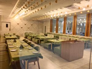 a dining room with green tables and chairs at Hotel Valley in Akteshwar