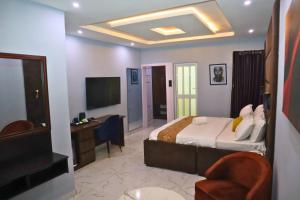 a hotel room with a bed and a television at El-Nido Hotel by Kdove in Omole