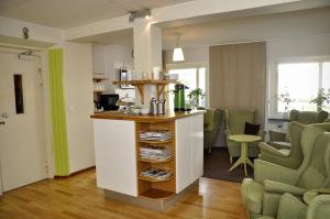 a kitchen and living room with green chairs at Ronneby Cityhotell in Ronneby