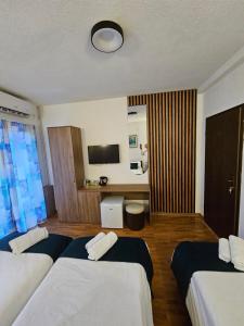a hotel room with three beds and a television at VN APARTMENTS OHRID in Ohrid